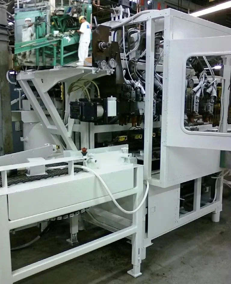 Industrial manufacturing machine freshly painted white, featuring hydraulic components, control panels, and conveyor equipment on a factory floor.