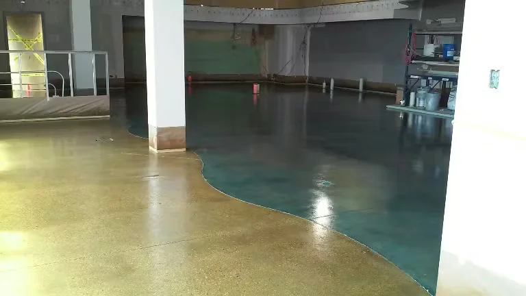 Polished stained concrete flooring in a commercial interior, featuring curved color transitions and a glossy finish around support columns.