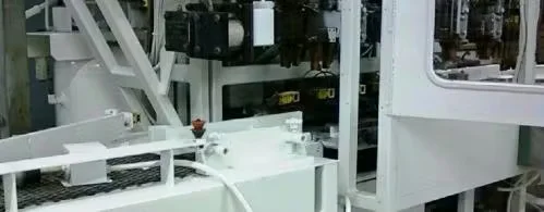 White-painted industrial manufacturing equipment inside a production facility, showing machinery frames, conveyors, and components prepared for industrial painting or maintenance.