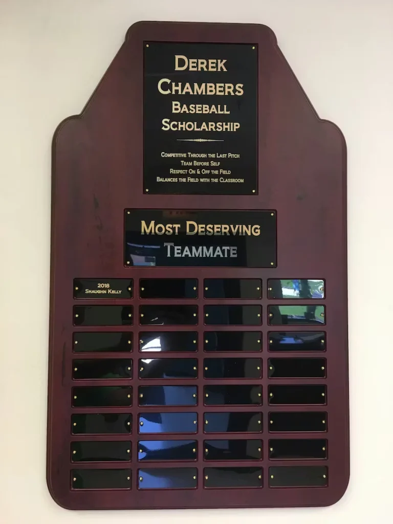 Plaque for the Derek Chambers Baseball Scholarship recognizing the “Most Deserving Teammate,” with engraved values and annual nameplates for recipients.