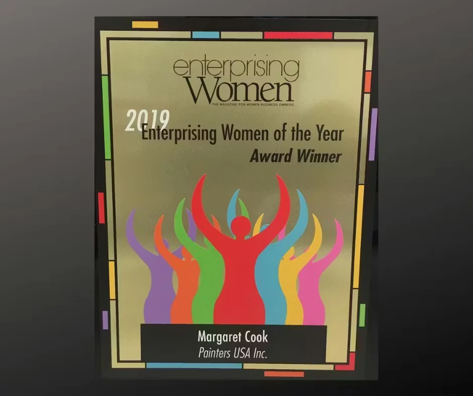 Plaque reading “Enterprising Women of the Year Award Winner” with colorful silhouettes of raised arms; name plate says “Margaret Cook, Painters USA Inc.” and the year 2019 is shown.