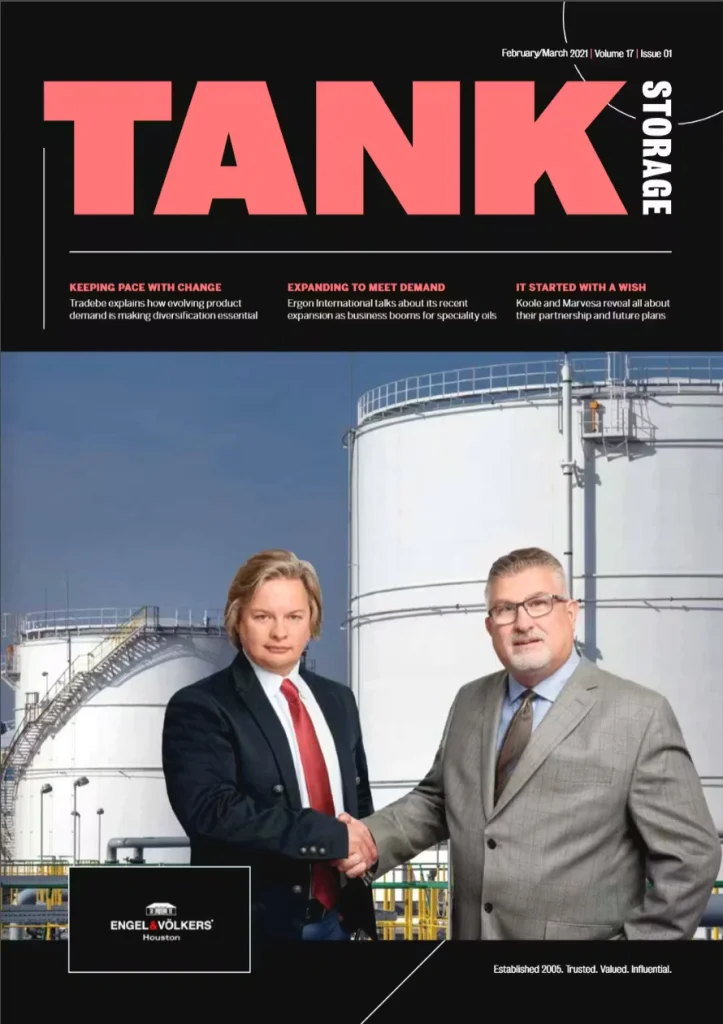 Magazine cover with large pink title “TANK” on a black header and the word “STORAGE” vertically on the right; below, two suited men shake hands in front of large white storage tanks under a blue sky, with issue date “February/March 2021” near the top.