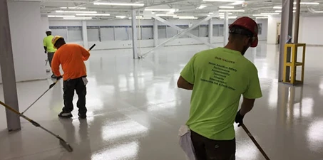 Epoxy flooring—workers applying epoxy coating to a large indoor floor, creating a durable and seamless surface.