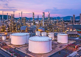 Chemical plants industry with large storage tanks and industrial towers at sunset.