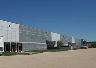 Warehouse and distribution industry exterior with loading docks and semi-truck access.