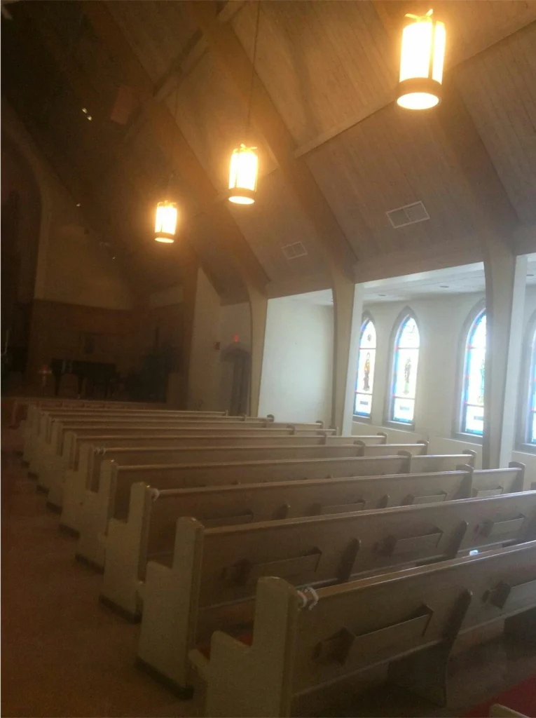 Brick church building with wide front steps and scaffolding near the entrance, partially blocked with caution tape.