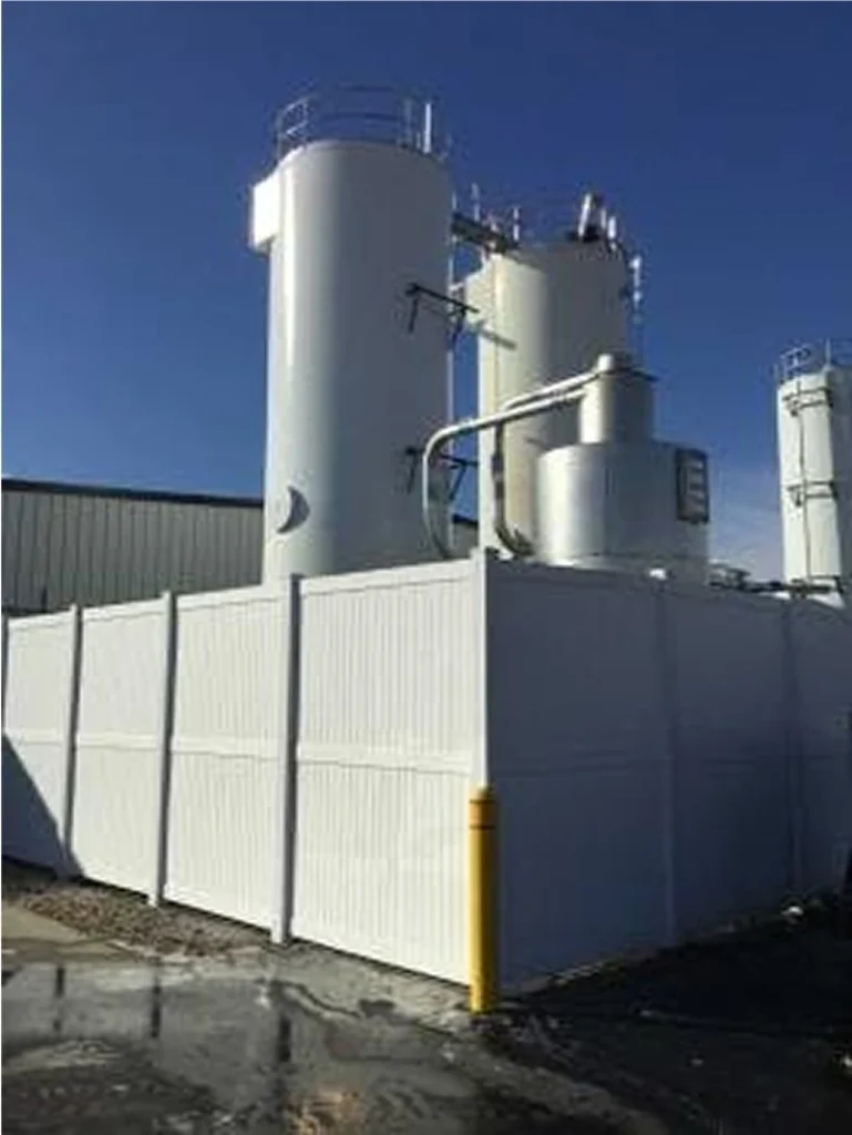 Finished project view of several bright white process tanks and piping under a clear sky after wet-vapor blasting and recoating.