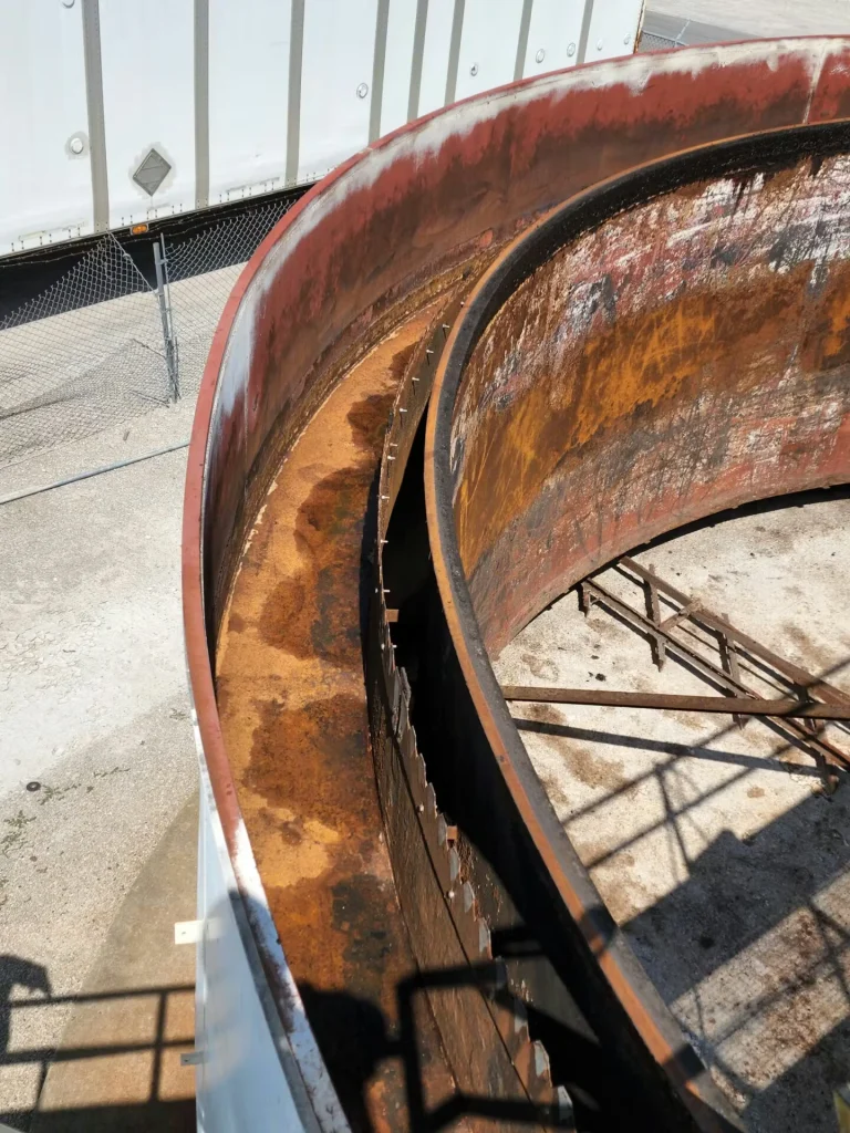 Angled view down into overlapping concentric rusted steel rings, showing worn surfaces and patchy discoloration along the inner rim.