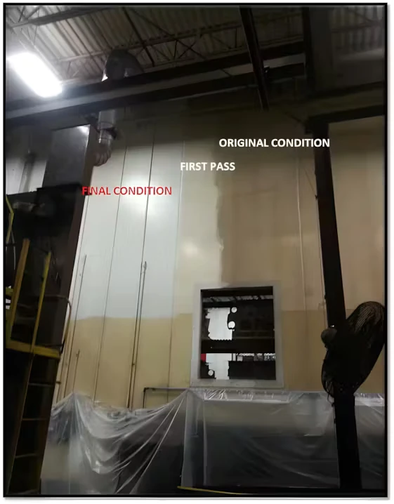 Indoor factory wall shown with labeled sections—“ORIGINAL CONDITION,” “FIRST PASS,” and “FINAL CONDITION”—highlighting a side-by-side comparison of cleaning results; plastic sheeting covers equipment below, with a ladder and overhead beams visible.