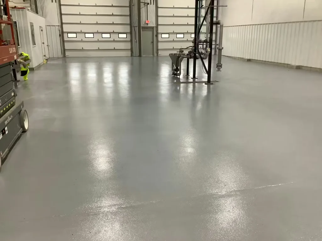 Wide view of industrial building with durable epoxy floor coating and manufacturing equipment.