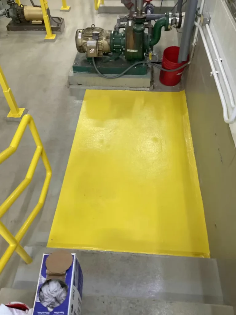 Pump equipment area with freshly coated yellow safety floor and motor assembly