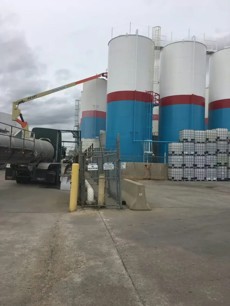 Industrial storage tanks with protective coating and lift access at manufacturing facility