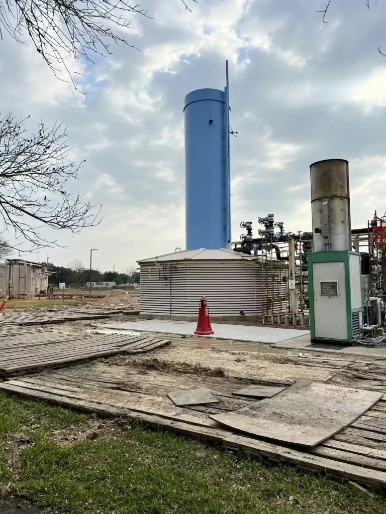 Tall blue process stack and surrounding industrial equipment at Shell technology center in Houston, Texas