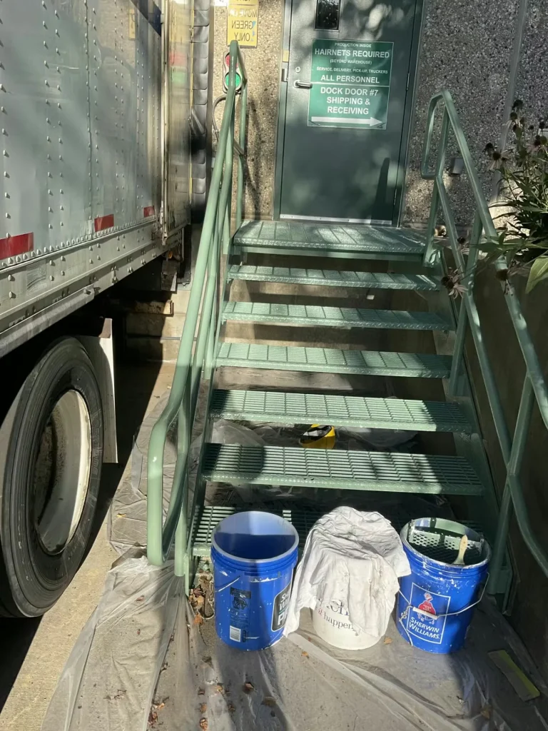 Exterior industrial metal stairs with fresh epoxy coating leading to dock door entrance