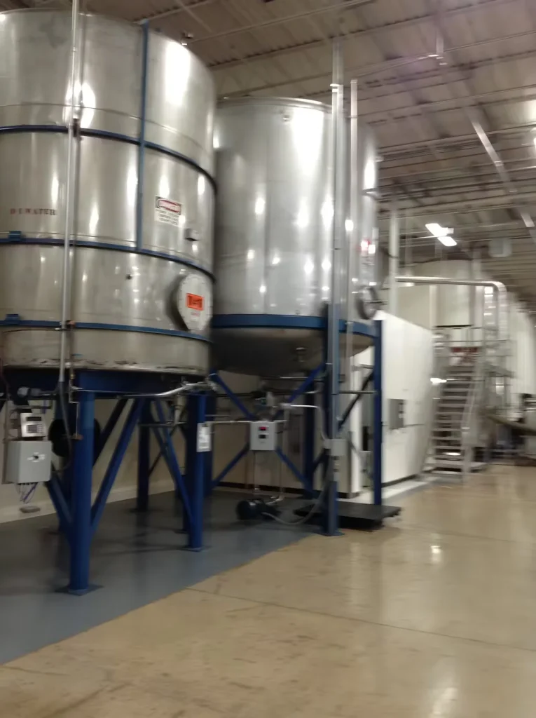 Stainless steel processing tanks and structural steel supports inside a food additive plant following repainting and floor coating work