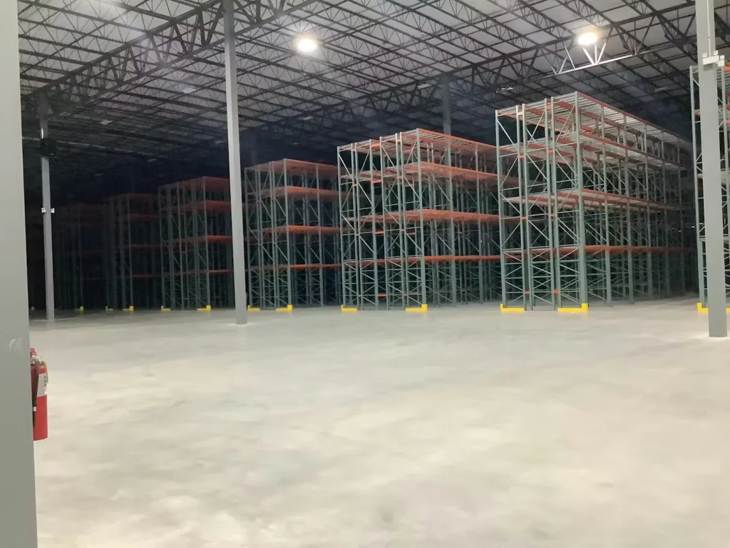 Wide warehouse interior with empty pallet racking and smooth concrete floor